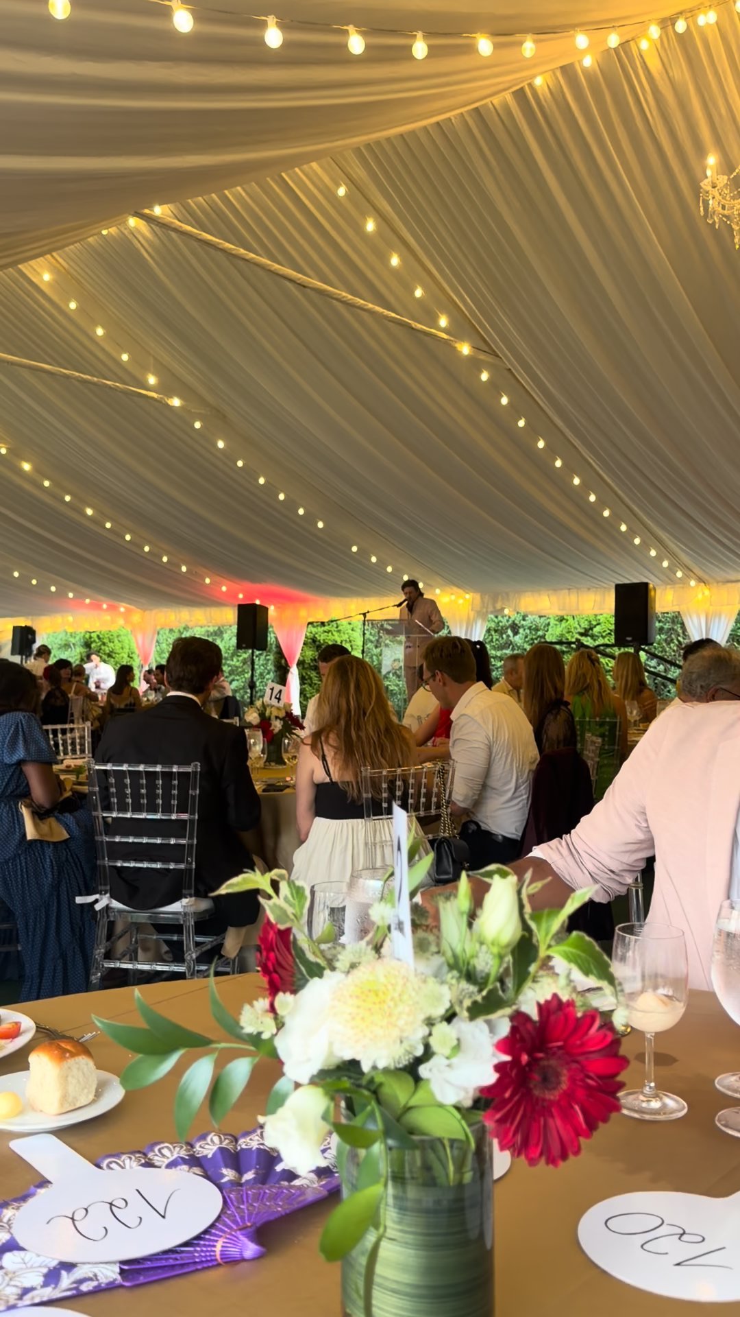 Long tables, dark florals, bulbs overhead.